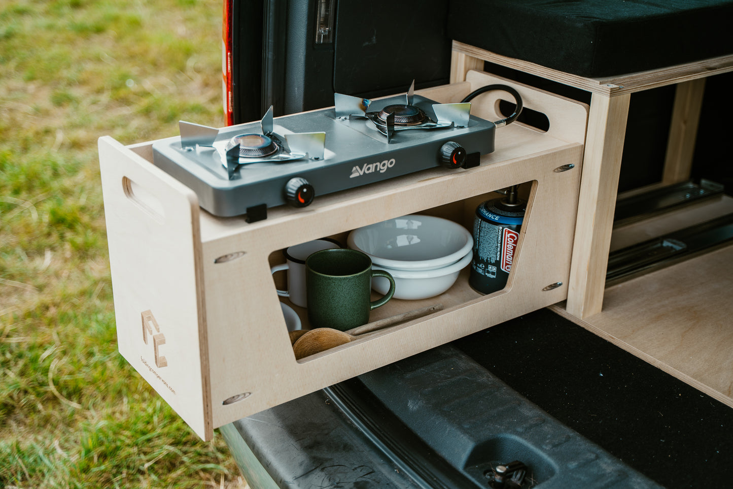 Kitchen drawer of camping conversion pulled out to show a stove setup.