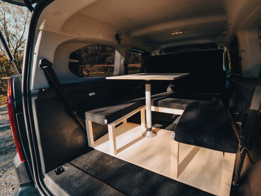 Van interior with a table and bench seats in a natural setting