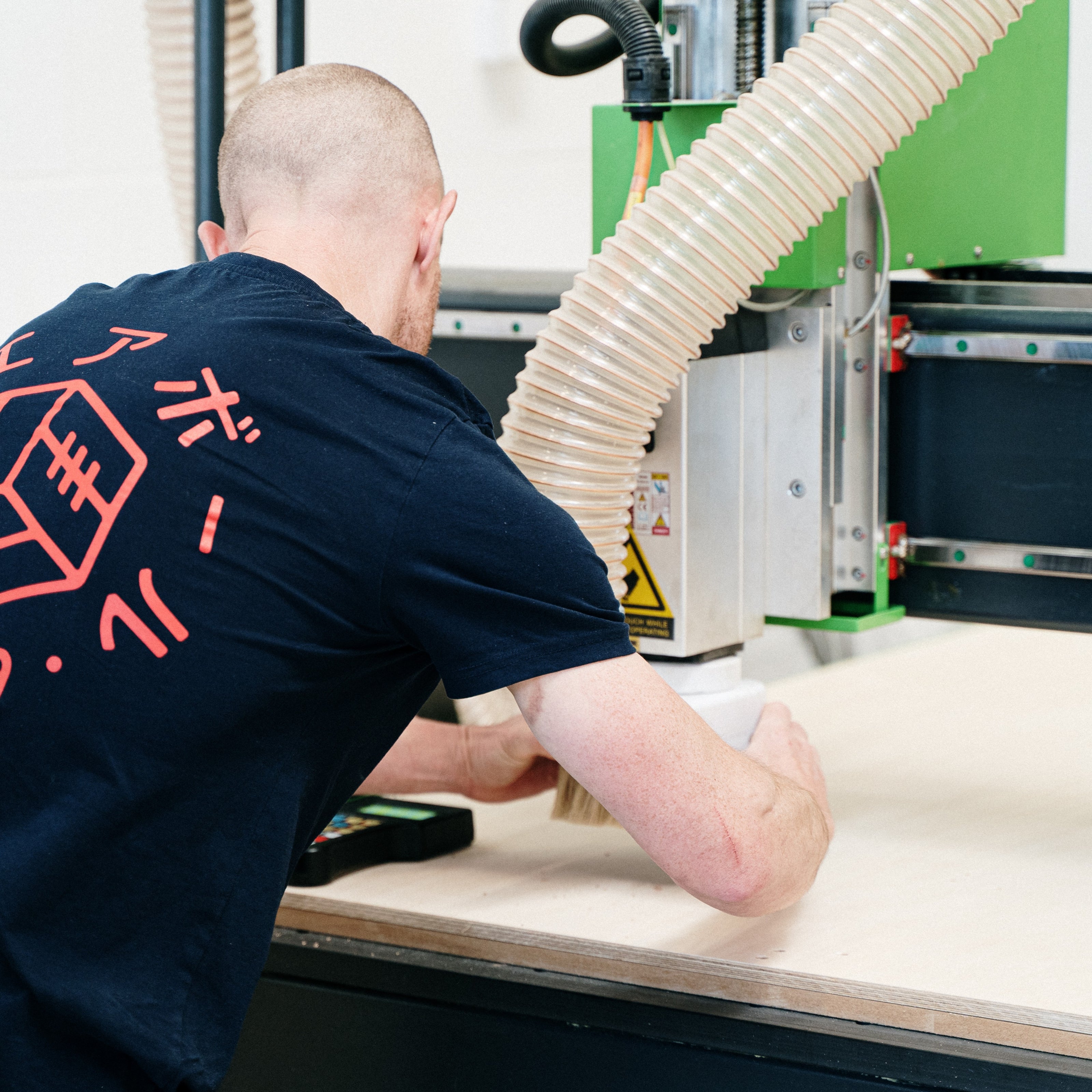 Person setting up CNC machine to process some birch plywood. 